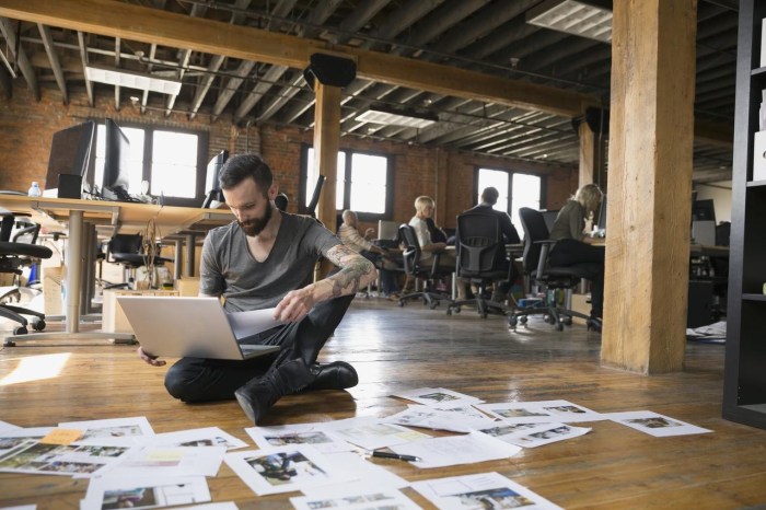 Businessman reviewing proofs on floor in office