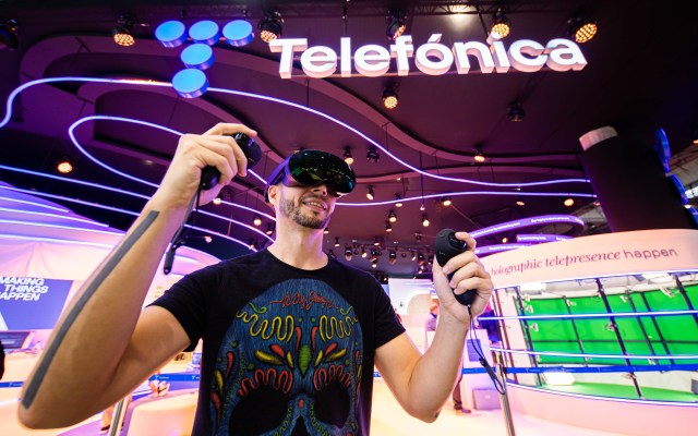 Person playing with virtual glasses in the Telefónica' stand at MWC23