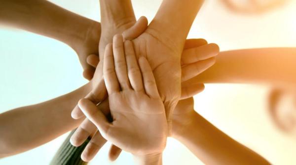 Code of business conduct: several people joining hands together as a team