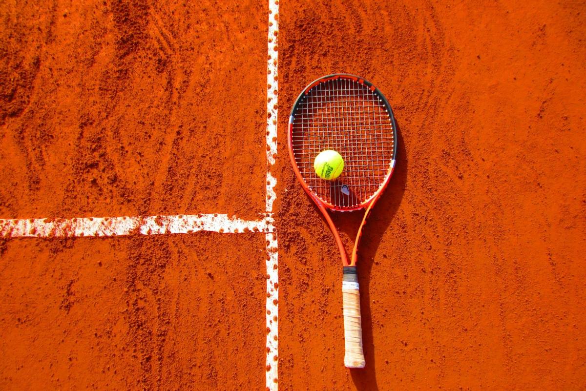 tennis ball on tennis racket on floor