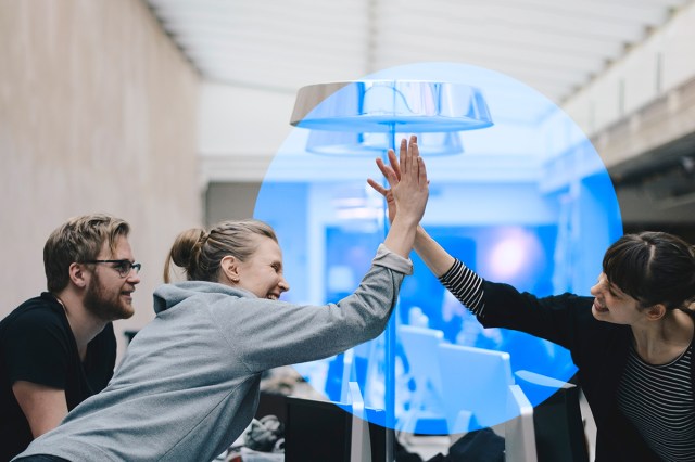 Work team high-fiving as a representation of Telefónica’s Principles for Customer Relationships