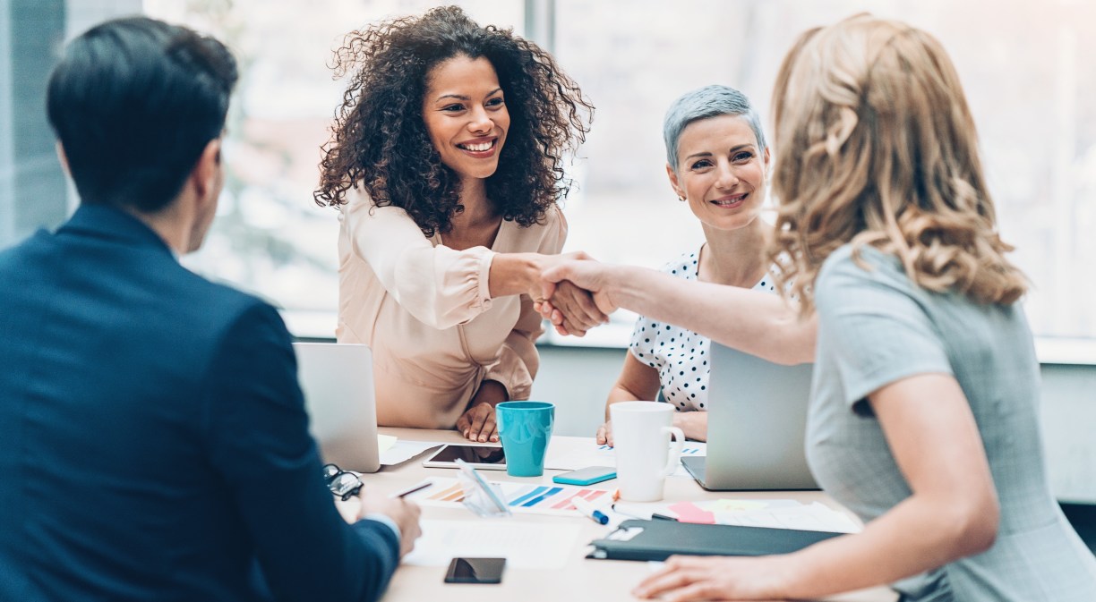 Empresarios dándose la mano en una reunión