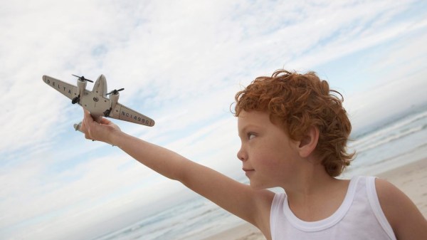Niño sujetando con avión de juguete