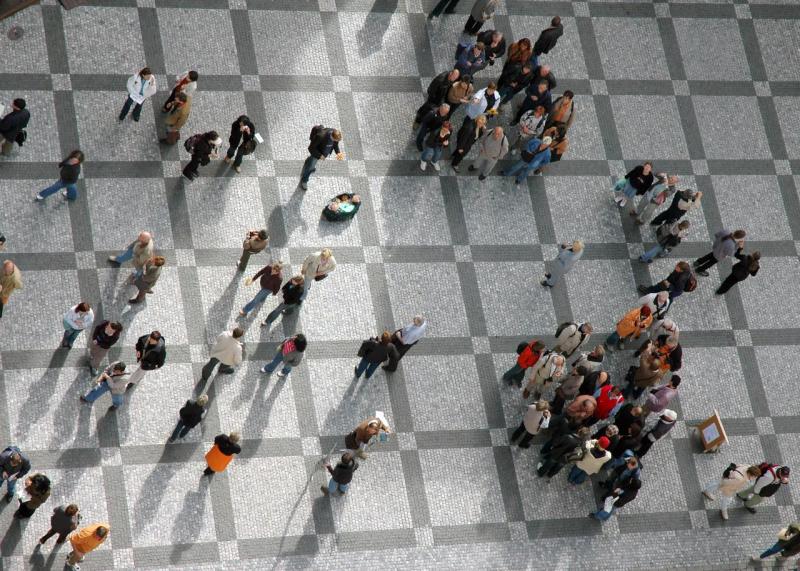 Vista aérea de personas en una plaza, reflejando la interacción social y la contribución socioeconómica de Telefónica.