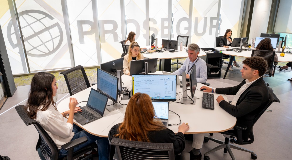 Varias personas trabajando en una oficina de Prosegur con ordenador
